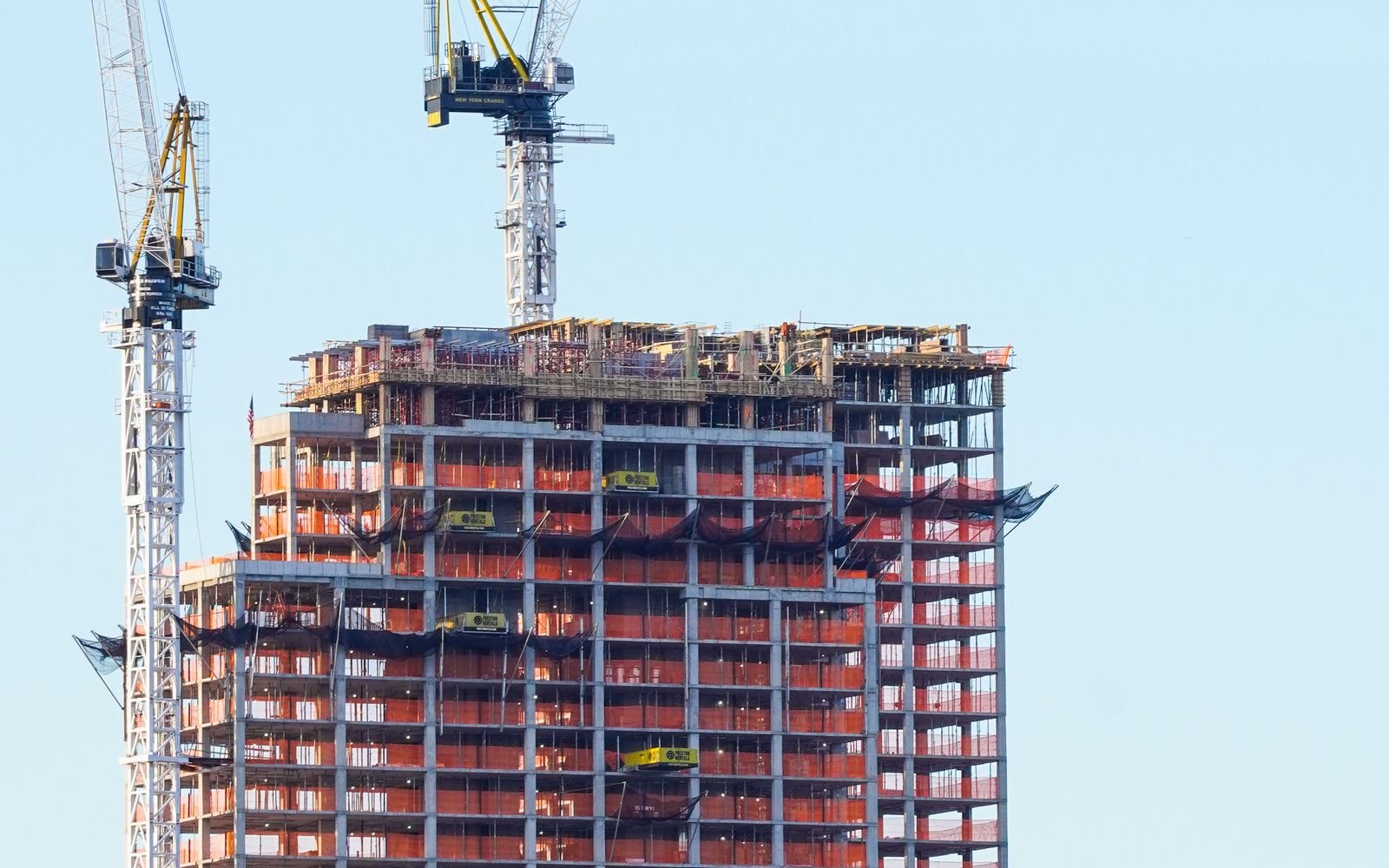 High-rise residential building under construction with cranes – ready-to-move vs under-construction property